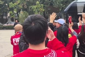 球迷夾道歡迎重慶銅梁龍球隊大巴，并高舉雙手喊“重慶雄起！”